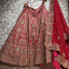 Red and gold lehenga skirt laid out showing gold motifs, zari and stone work bands and scalloped cutwork dupatta