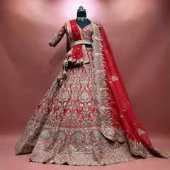 Red and gold lehenga set on a mannequin with scalloped cutwork organza dupatta and embroidered belt