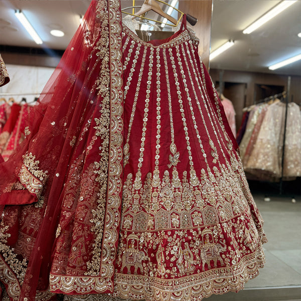 Maroon lehenga skirt with gold motifs, scalloped borders, and embroidered net dupatta