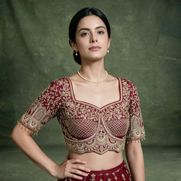 Maroon embroidered bridal blouse with square neckline and gold trim; lehenga waist