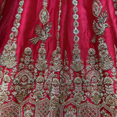Rani pink raw silk lehenga close-up with embroidered birds, sequin medallion columns and arched floral motifs
