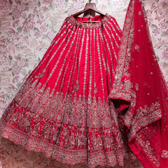 Rani pink raw silk lehenga with elephant procession hem and embroidered net dupatta on hanger