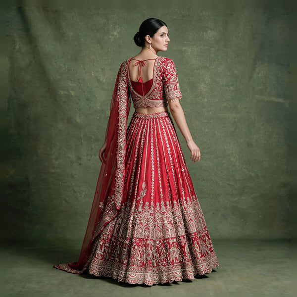 Red bridal lehenga with embroidered blouse and draped dupatta, side/back view