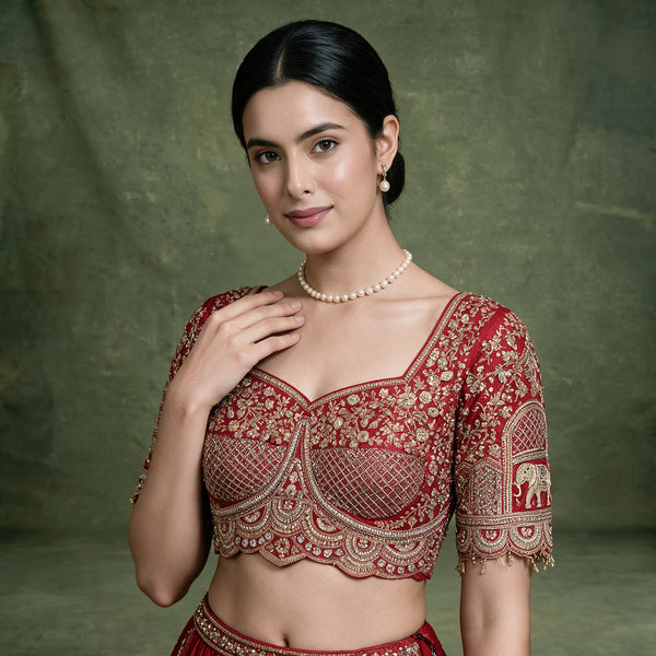 Red embroidered blouse with square neckline and pearl necklace detail, close-up