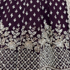 Close-up of wine fabric with silver beaded floral and geometric embroidery