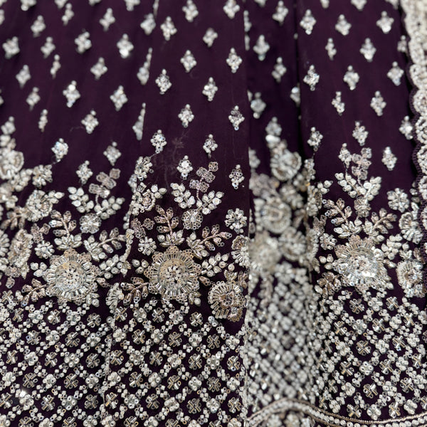 Close-up of wine fabric with silver beaded floral and geometric embroidery