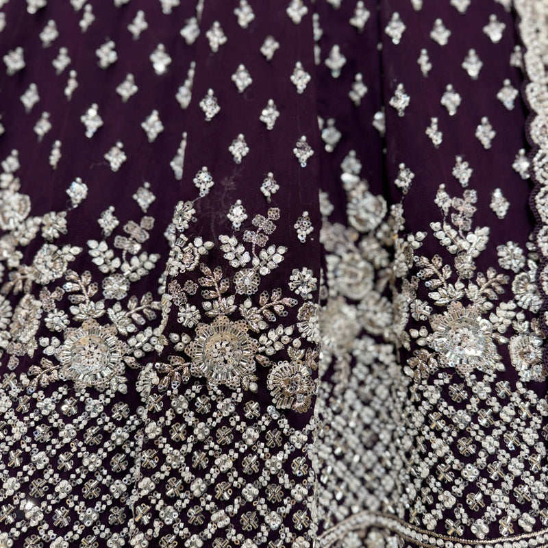 Close-up of wine fabric with silver beaded floral and geometric embroidery