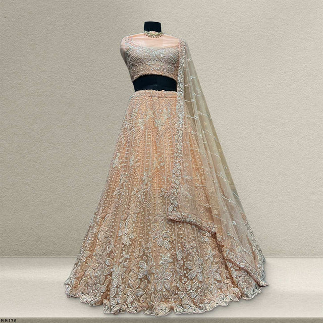 Pastel peach embellished lehenga with net dupatta on dress form
