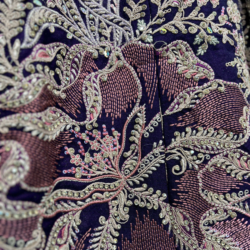Close-up of dark purple lehenga embroidery with silver sequins and pink accents