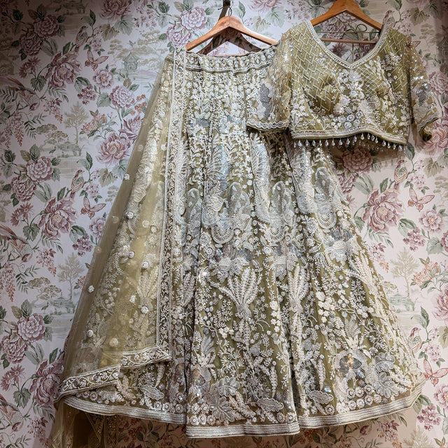 Embroidered lehenga and blouse on hangers, sage green with silver-toned beadwork