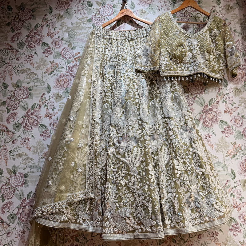 Embroidered sage green lehenga set with matching blouse, skirt, and sheer dupatta