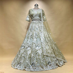 Ivory and sage green embroidered lehenga on mannequin with draped sheer dupatta