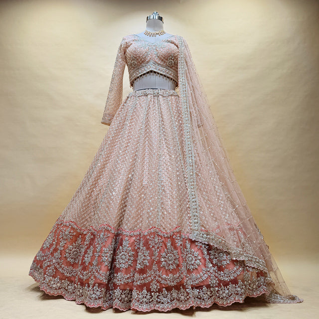 Peach net lehenga with heavy embroidered yoke, matching border and long sleeves blouse
