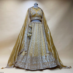 Embroidered somber yellow lehenga set on mannequin, with layered skirt and sheer dupatta