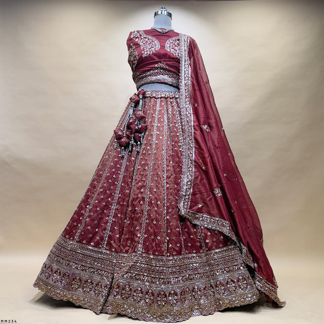 Rust-brown lehenga with matching blouse, mirror and beadwork border