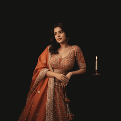 Orange lehenga with short-sleeve blouse, deep V yoke, silver embroidered trim and belt