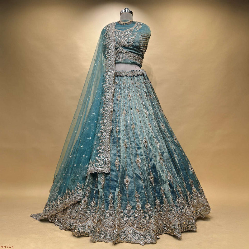 Teal embroidered lehenga with paneled skirt, silver-gold border and beaded motifs