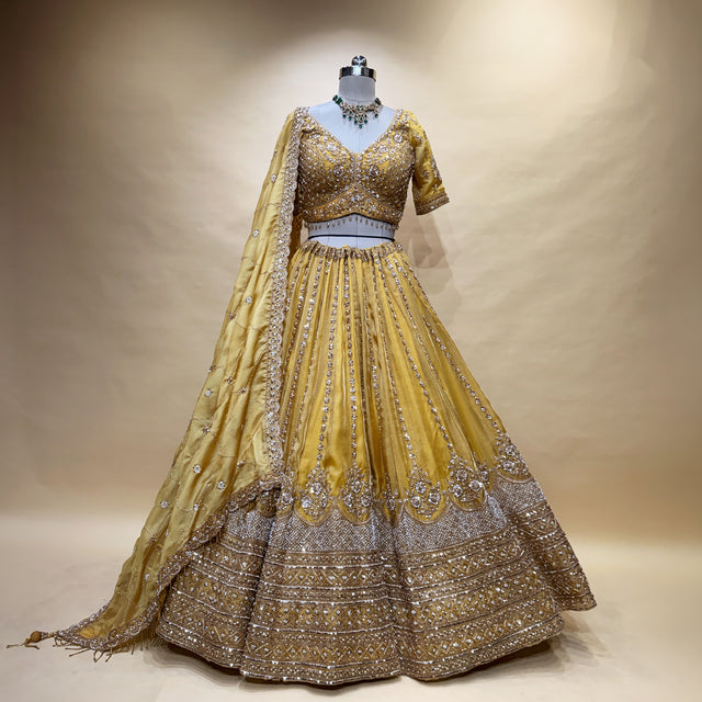 Mustard gold lehenga with ornate beadwork hem and matching embroidered sleeves