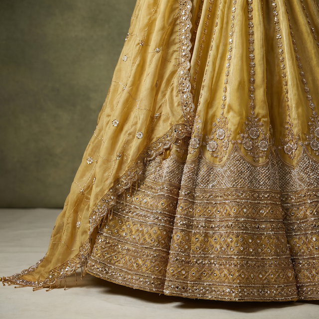 Gold dupatta with bead and cutdana trim over mustard pleated lehenga skirt
