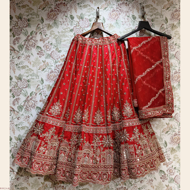 Red bridal lehenga and matching dupatta set with gold embroidery, on hangers