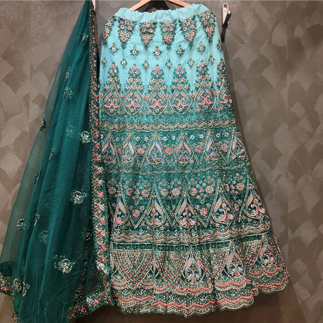 Green and teal lehenga skirt with ornate embroidered tiers and floral border