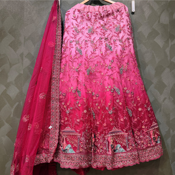 Embroidered pink lehenga skirt with decorative hem and net dupatta drape