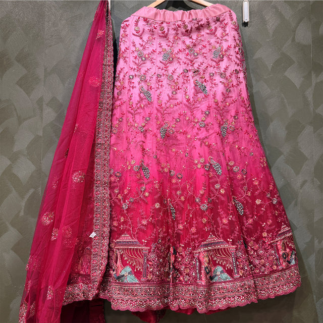 Embroidered pink lehenga skirt with decorative hem and net dupatta drape