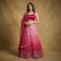 Pink embroidered lehenga set with satin blouse and sheer net dupatta, flared skirt