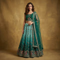 Teal-green lehenga set with embroidered blouse, flared skirt, and net dupatta
