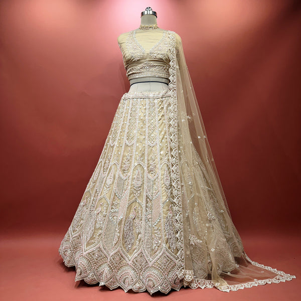 Ivory embellished lehenga with matching net dupatta, peacock motif skirt on mannequin