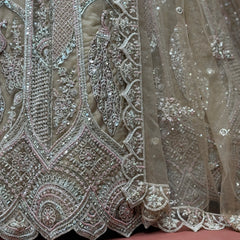 Close-up of ivory net lehenga embroidery with cutdana, dori lines, and peacock motifs