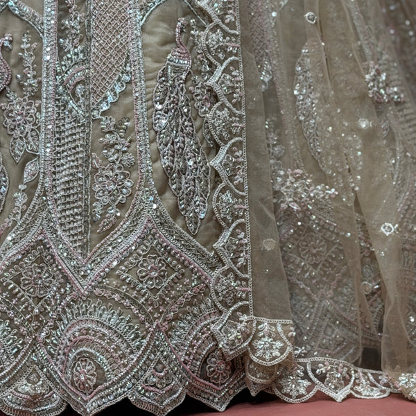 Close-up of ivory net lehenga embroidery with cutdana, dori lines, and peacock motifs