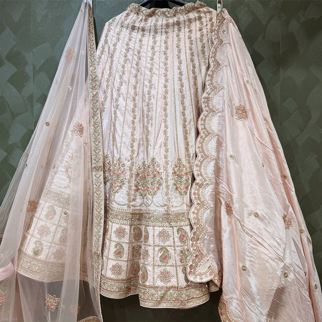 Pastel pink lehenga with gold trim and multicolor embroidery, with sheer dupatta