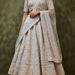 Sky blue lehenga skirt with dense silver mirrorwork motifs and ornate gold-toned border