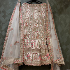 Ivory bridal lehenga with richly embroidered front and matching sheer dupatta