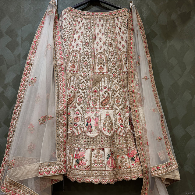 Ivory bridal lehenga with richly embroidered front and matching sheer dupatta