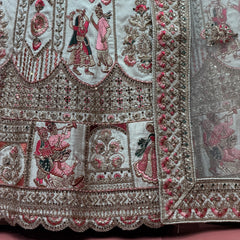 Close-up of embroidered ivory bridal lehenga hem with multicolored motifs