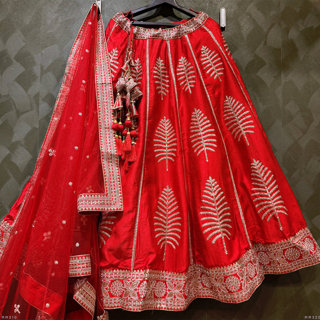Red bridal lehenga with gold embroidery, flared skirt, and sheer dupatta