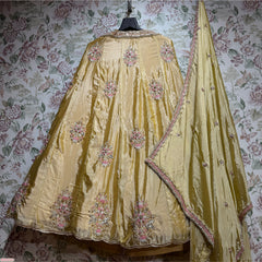 Butter yellow silk lehenga with embroidered floral motifs and embellished border