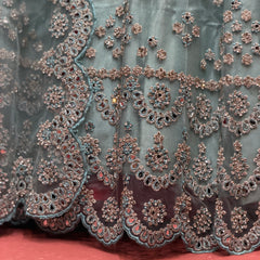 Sky blue net lehenga close-up of mirror and stone embroidery with scalloped lace trim