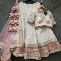 Ivory Lucknowi lehenga with pink patchwork border, blouse and net dupatta on hanger