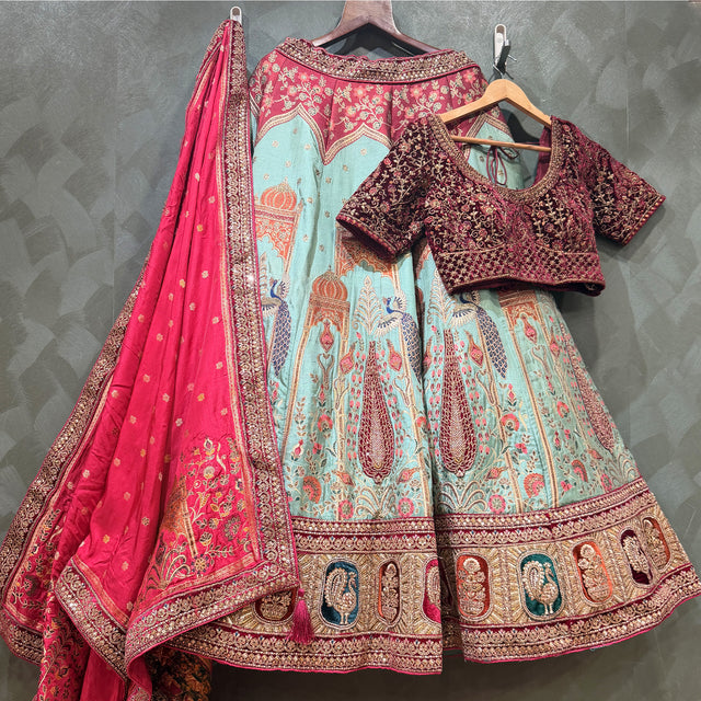 Festive Banarasi lehenga set on hangers: teal skirt with pink dupatta and maroon blouse