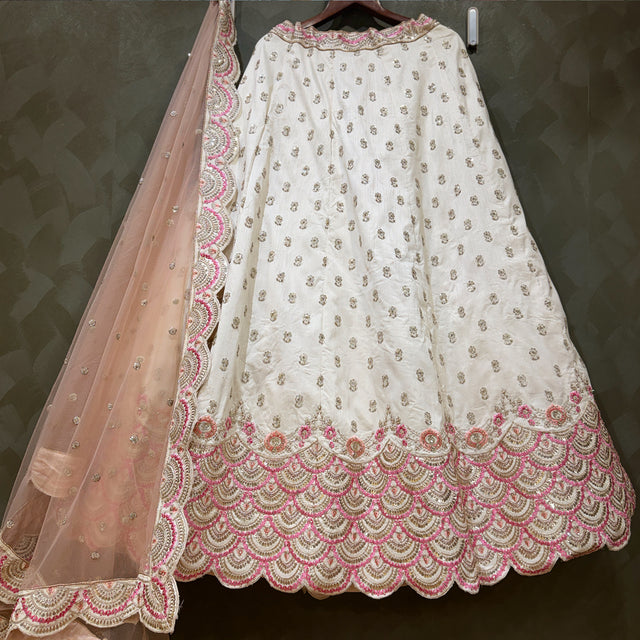 Ivory lehenga with pink-and-gold scalloped border hem and sheer pink dupatta