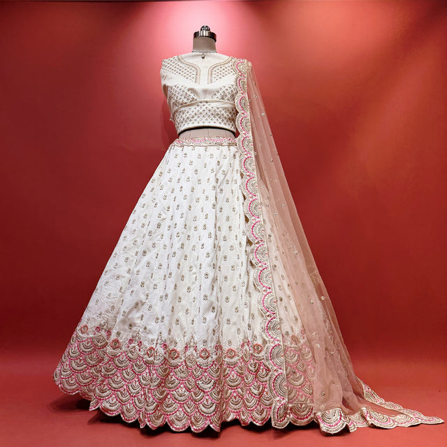 Ivory lehenga with pink and gold scalloped hem and embroidered bodice detail
