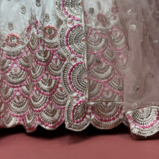 Ivory lehenga hem with ornate pink, gold, and silver scalloped sequin embroidery