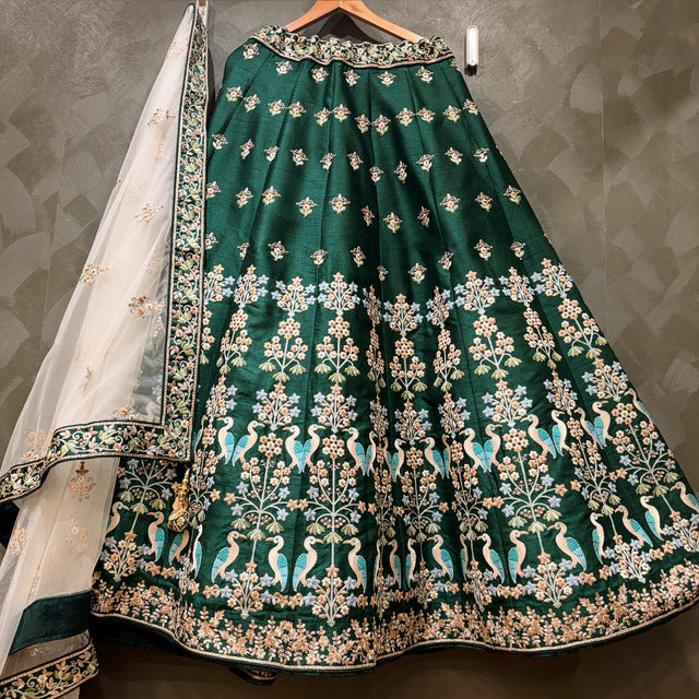 Deep green raw silk lehenga with all-over gold and floral embroidery border