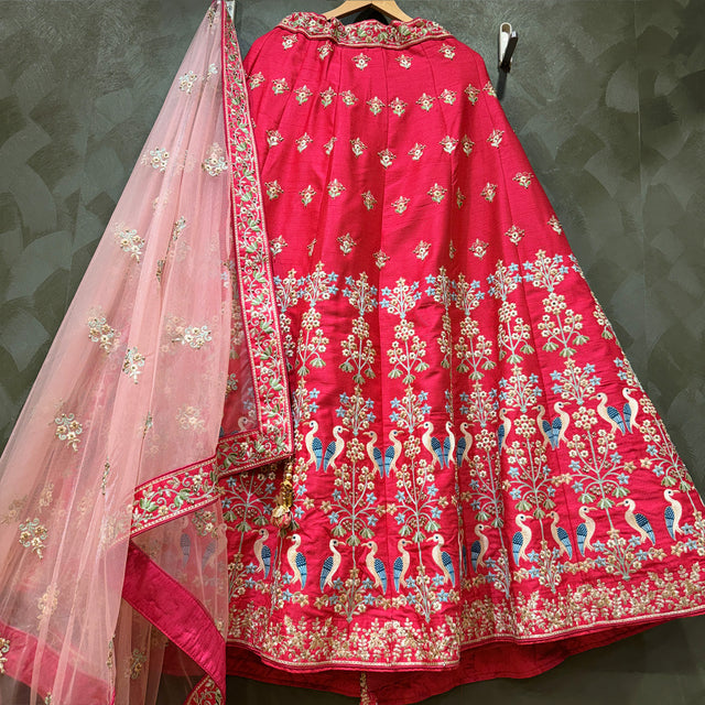 Pink raw silk lehenga with threadwork, peacock motifs, and embroidered border; sheer dupatta
