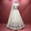 Ivory tissue silk lehenga skirt with sheer overlay and ornate peacock motif hem embroidery
