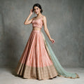 Peach raw silk bridesmaid lehenga with gold butis and embroidered hem, worn with net dupatta