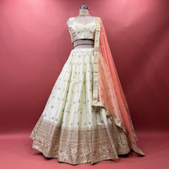 Pista green raw silk lehenga set with blouse and net dupatta on mannequin
